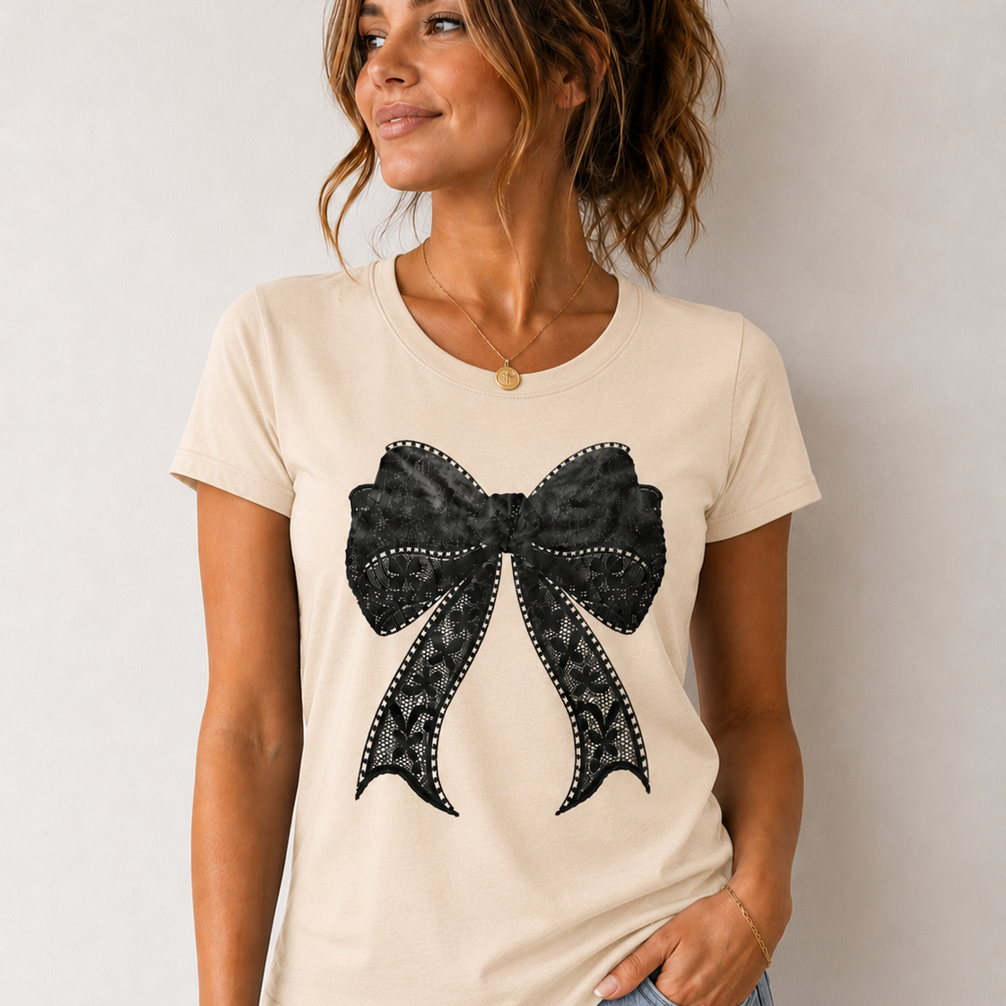 Woman wearing a cream t-shirt with a black bow design on a plain background