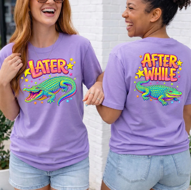 Woman wearing a violet Later After While alligator graphic t-shirt with colorful retro front and back alligator designs.