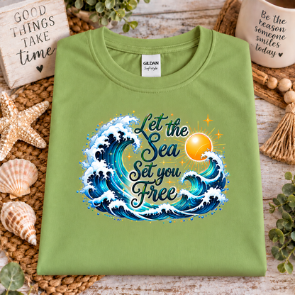 A kiwi green colored gildan softstyle t-shirt with a graphic design with the words "Let the Seas set you free" surrounded by ocean waves and a sun