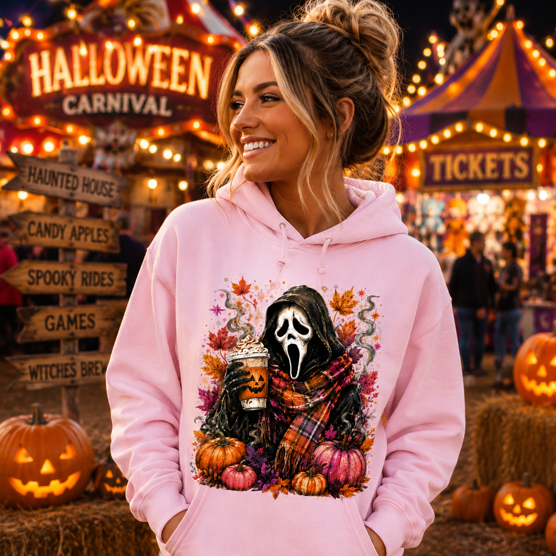 A woman wearing a light pink hoodie with a graphic of Ghostface surrounded by pumpkins, autumn leaves, and a plaid scarf, set against a festive Halloween carnival background.