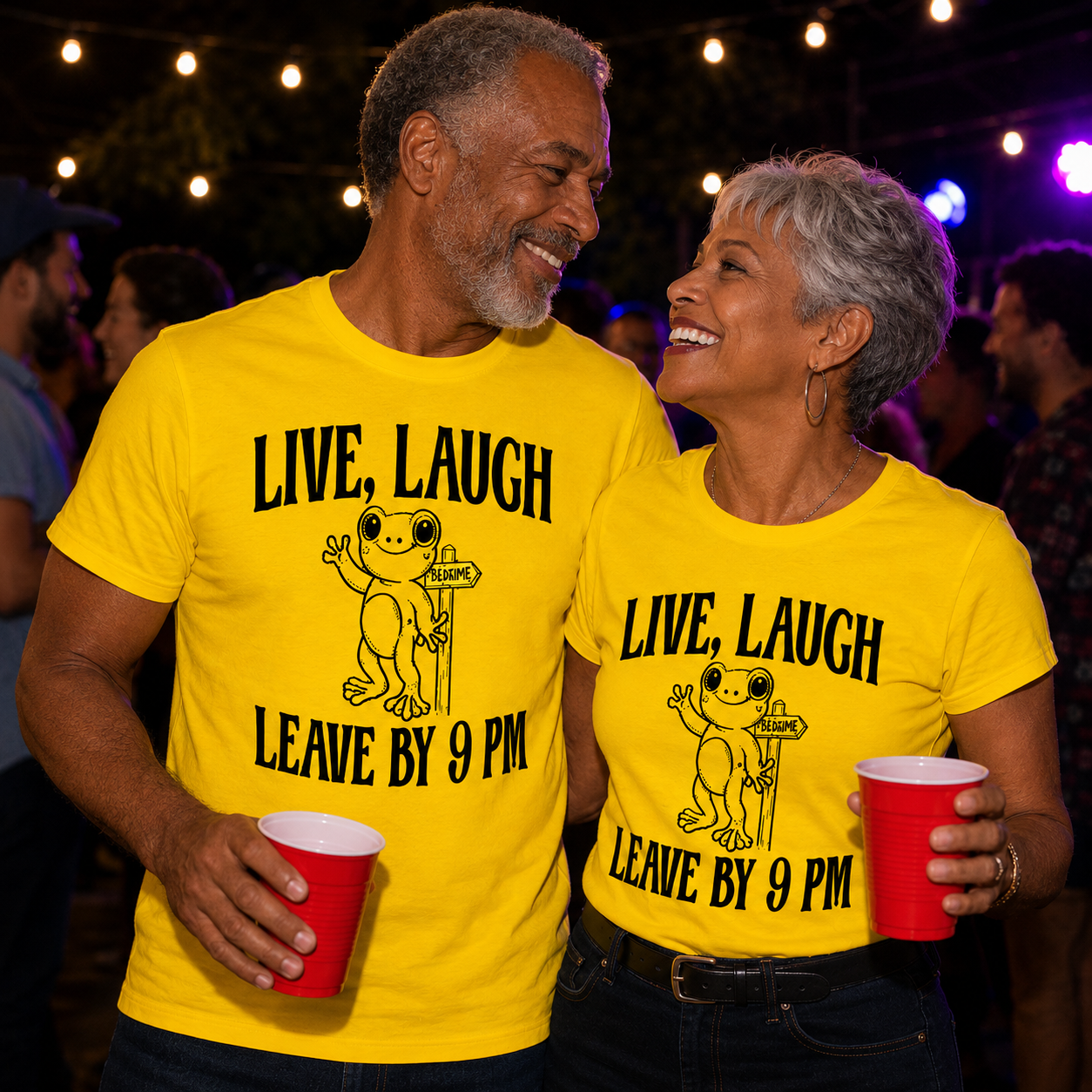 Two people wearing matching daisy colored t-shirts with a frog graphic and text "Live, Laugh Leave by 9pm holding red cups in a social setting.