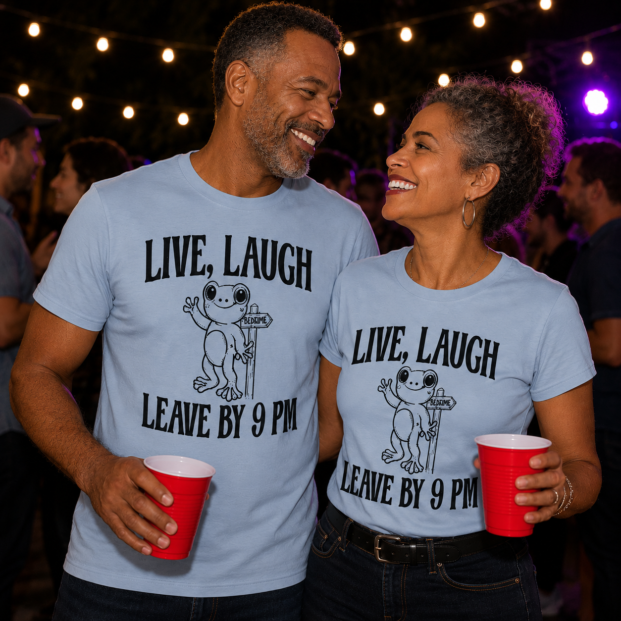 Two people wearing matching light blue colored t-shirts with a frog graphic and text "Live, Laugh Leave by 9pm holding red cups in a social setting.