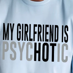 A person wearing a light blue t-shirt with the text 'MY GIRLFRIEND IS PSYCHOTIC' printed on the front in bold, capital letters.