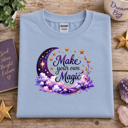 Light blue t-shirt with moon, stars and clouds graphic with the Text Make your own Magic