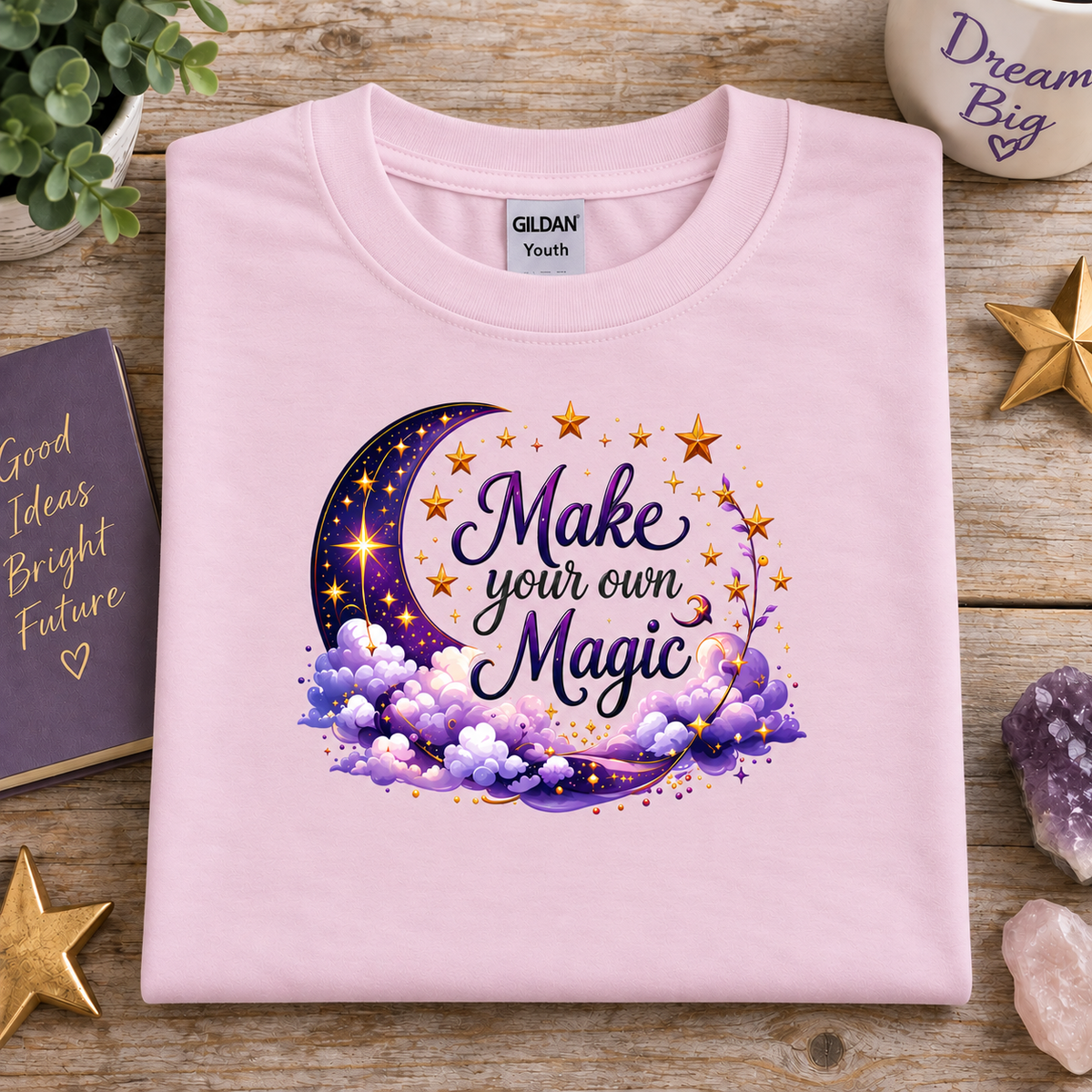Light pink t-shirt with moon, stars and clouds graphic with the Text Make your own Magic