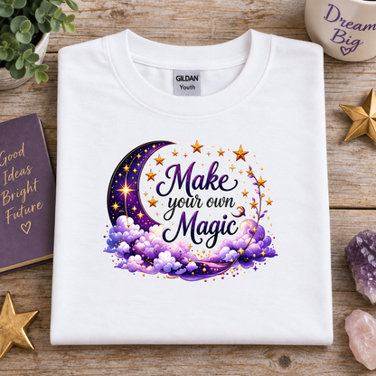 White t-shirt with moon, stars and clouds graphic with the Text Make your own Magic