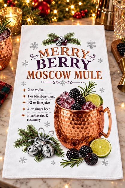 A white kitchen tea towel featuring a festive 'Merry Berry Moscow Mule' recipe and a graphic of a copper mug with berries, displayed on a marble surface with holiday lights and copper mugs in the background.