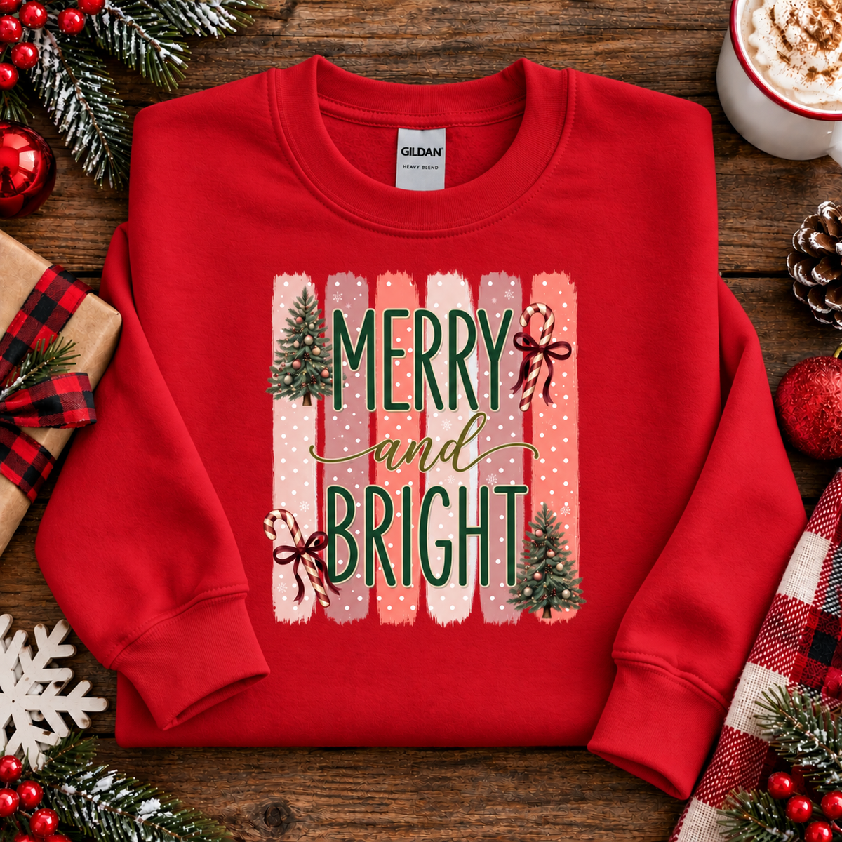 Merry and Bright Christmas graphic on a red sweatshirt with striped pink and coral background, white polka dots, green lettering, candy canes with red bows, and two decorated Christmas trees.