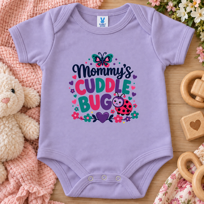 A lavender colored baby bodysuit has a colorful graphic reading “Mommy’s Cuddle Bug” with a butterfly, flowers, hearts, and a ladybug.