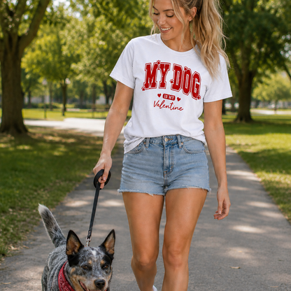 Woman walking a dog in a park wearing a white t-shirt with red text My Dog is my Valentine