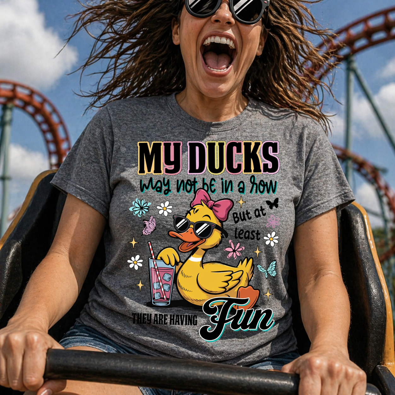 Person wearing a t-shirt with a duck graphic and text at an amusement park.