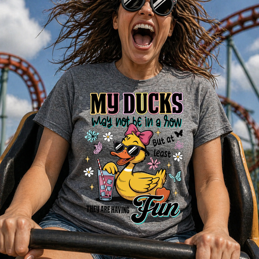 Person wearing a t-shirt with a duck graphic and text at an amusement park.