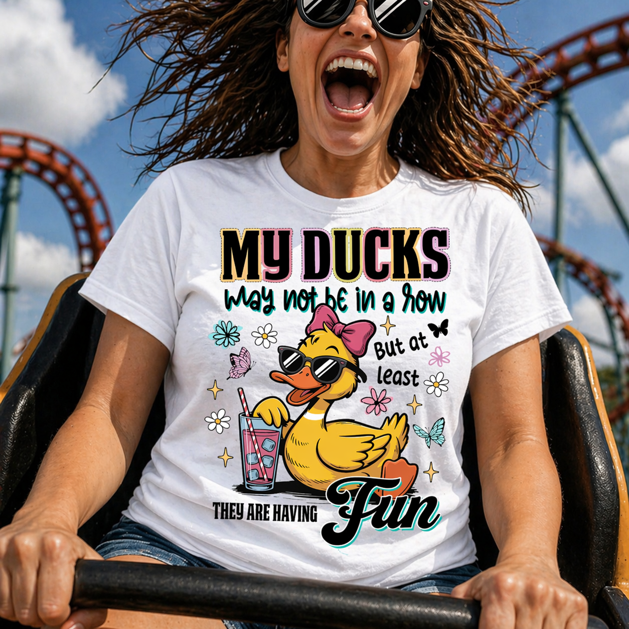 Person wearing a t-shirt with a duck graphic and text, riding a roller coaster.