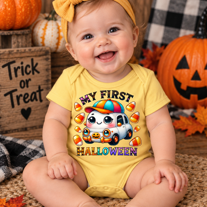 A smiling baby wearing a yellow short-sleeve bodysuit with a colorful cartoon car and the words 'MY FIRST HALLOWEEN' surrounded by candy corn, seated in a fall-themed setting with pumpkins and autumn decor.