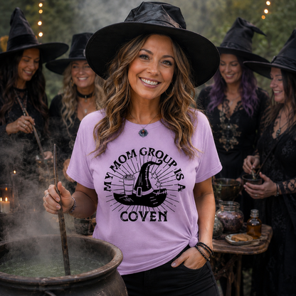Woman wearing a purple t-shirt with a witch hat design and text, surrounded by people in witch costumes.