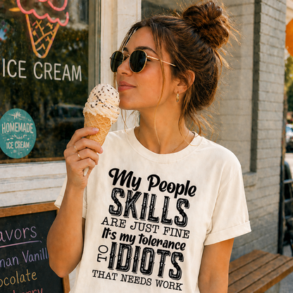 Woman eating ice cream wearing an Ivory colored t-shirt with humorous text in front of an ice cream shop.
