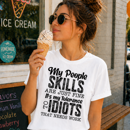 Woman wearing a white t-shirt with humorous text, eating ice cream outside an ice cream shop.