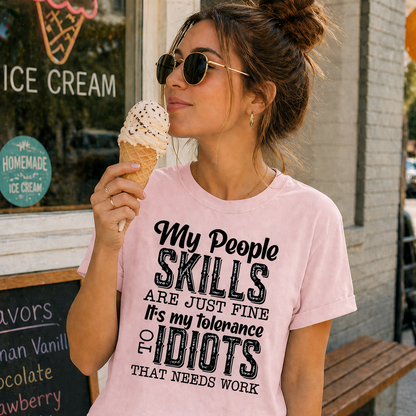 Woman wearing a pink t-shirt with humorous text, holding an ice cream cone outdoors.