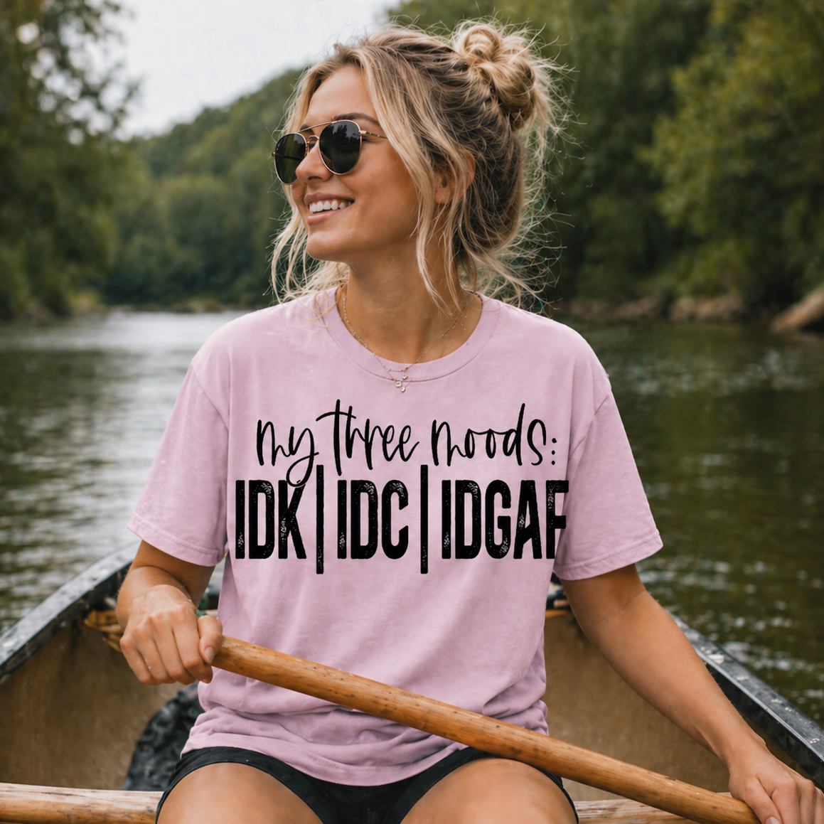 Woman in a light pink t-shirt with humorous text on a boat on a lake