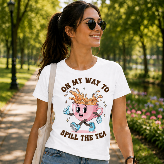 White shirt with a cartoon pink cup character and text 'On my way to spill the tea' on a denim jacket background.