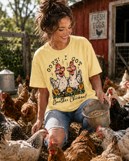 Woman in butter colored shirt with chicken graphic and text oops I got another chicken