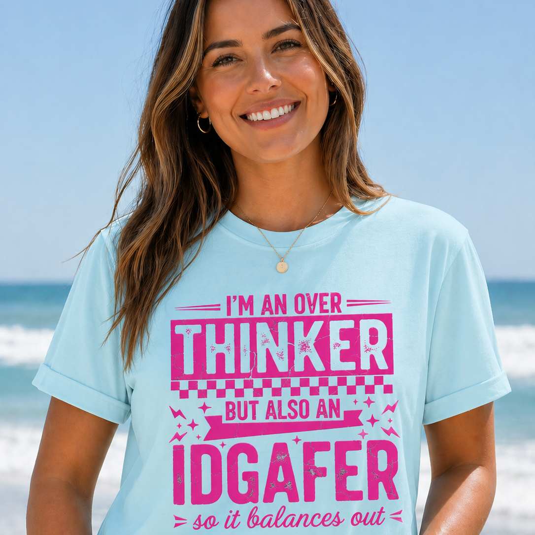 Woman wearing a light blue t-shirt with pink text on a beach