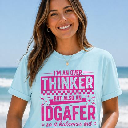Woman wearing a light blue t-shirt with pink text on a beach