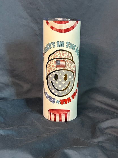 Tumbler with a design of a smiling face wearing a helmet with an American flag on a dark background