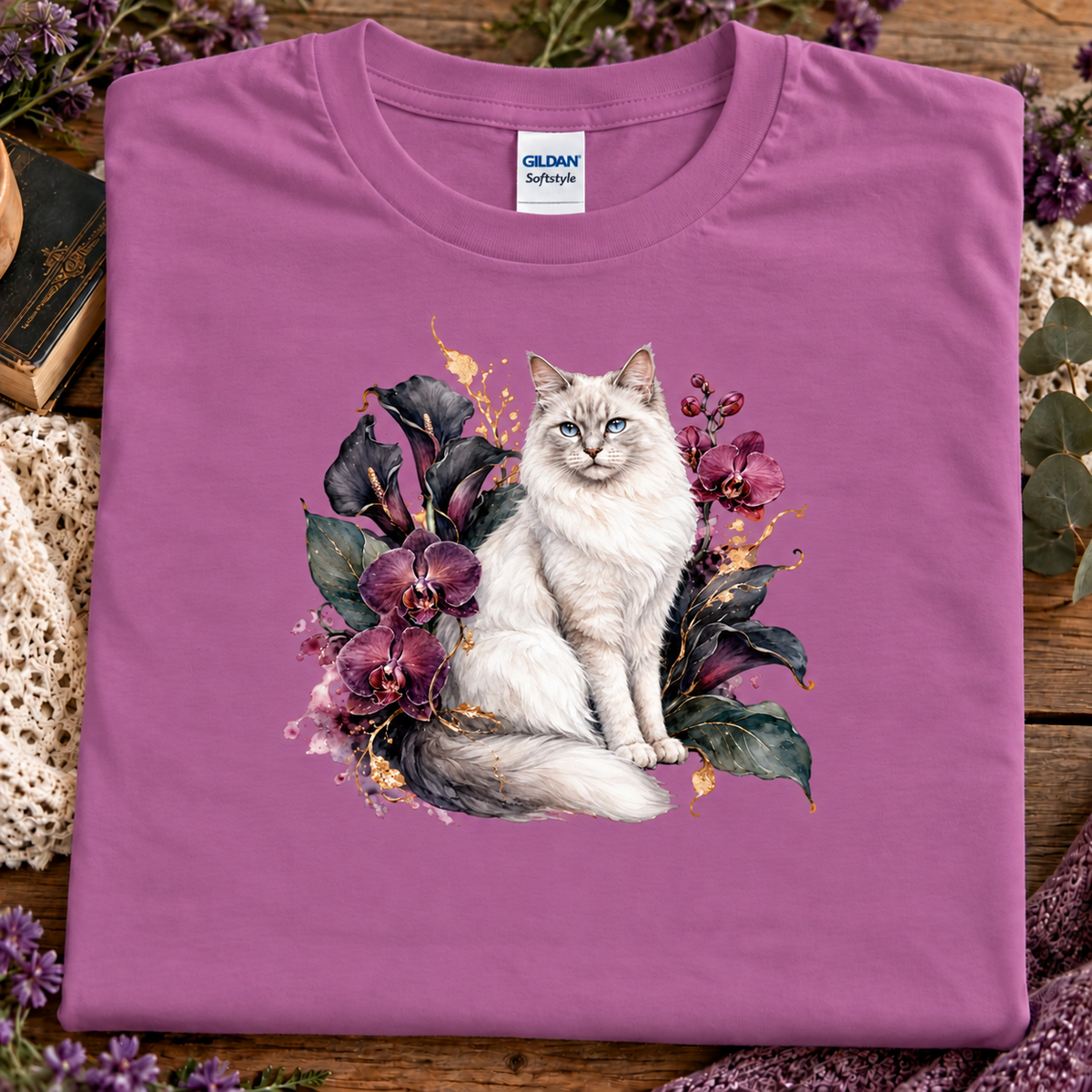 A heather radiant orchid colored t-shirt with a ragdoll Cat surrounded by a velvet garden of orchids.