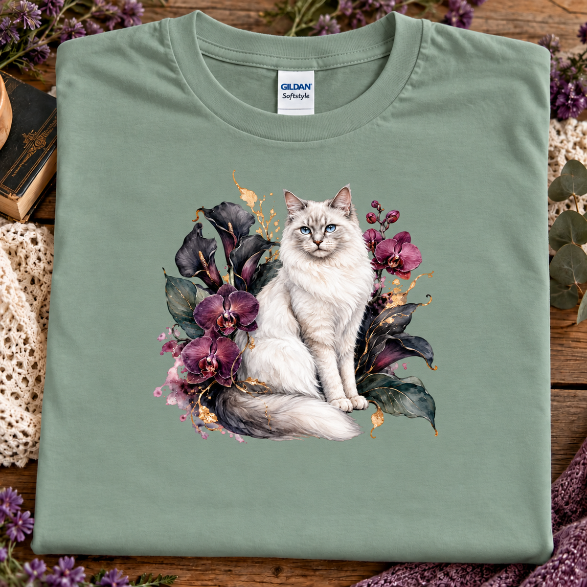 A sage colored t-shirt with a ragdoll Cat surrounded by a velvet garden of orchids.