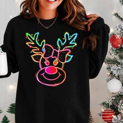 Person wearing a black shirt with a colorful neon reindeer design in front of a Christmas tree.