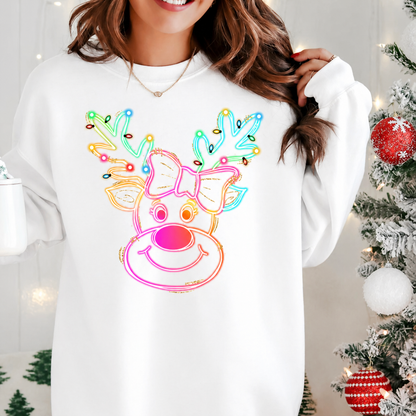 Person wearing a white sweatshirt with a colorful neon reindeer design in a festive setting. 