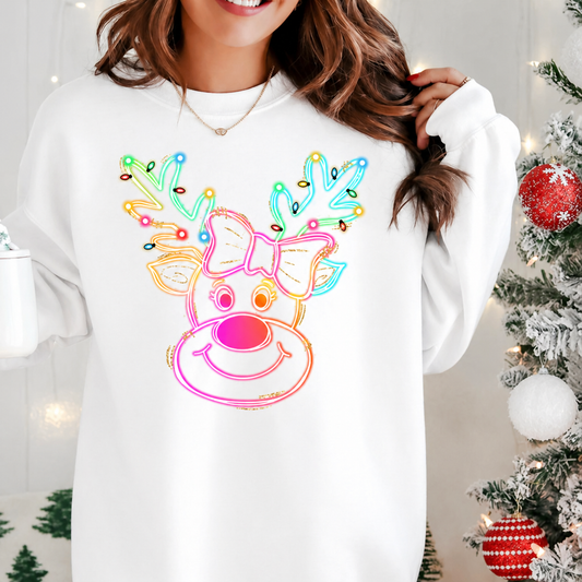 Person wearing a white sweatshirt with a colorful neon reindeer design in a festive setting. 