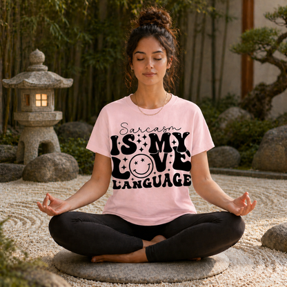 Woman meditating outdoors wearing a blossom colored t-shirt with the Sarcasm is my Love Language text