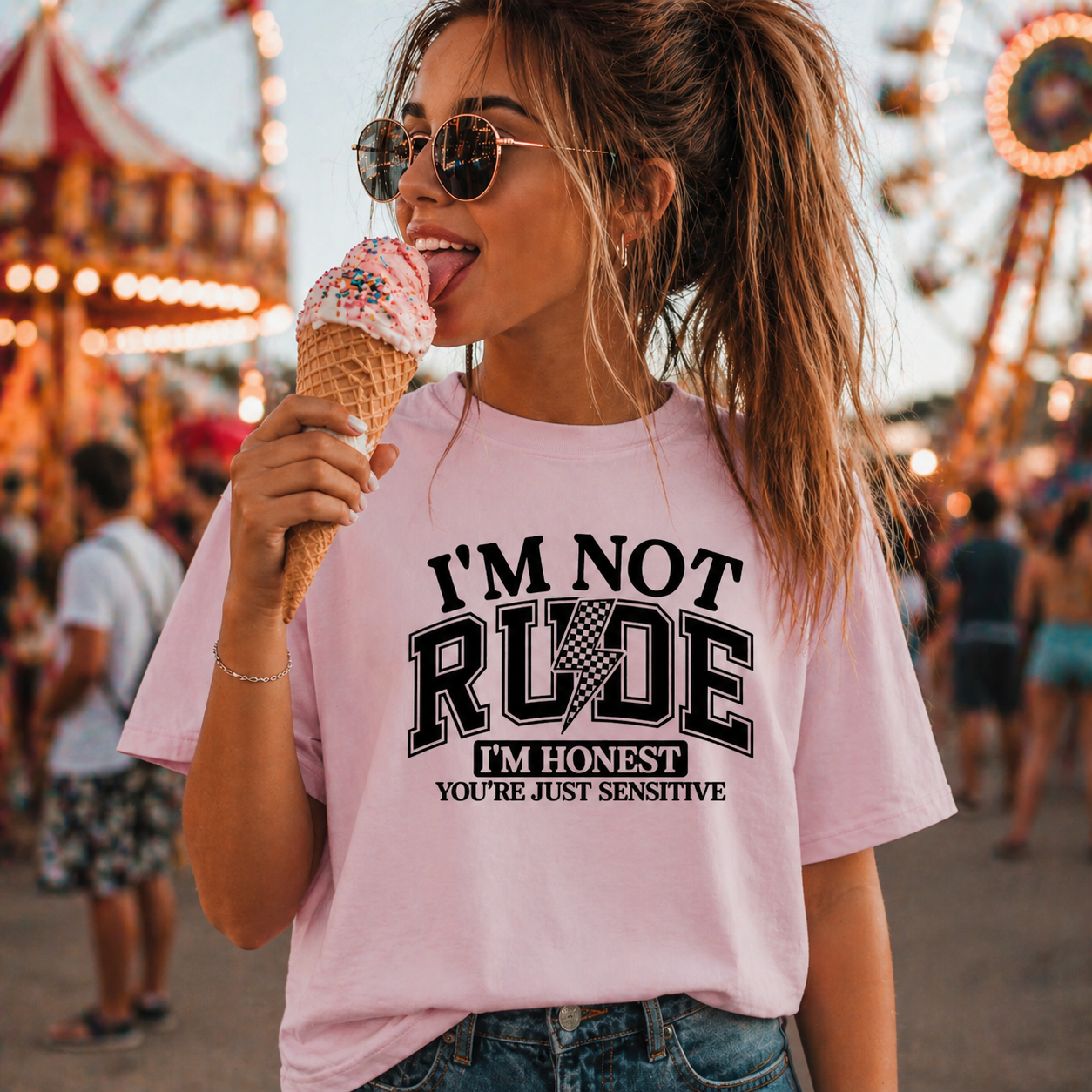 Woman wearing a pink graphic t-shirt with text at an amusement park