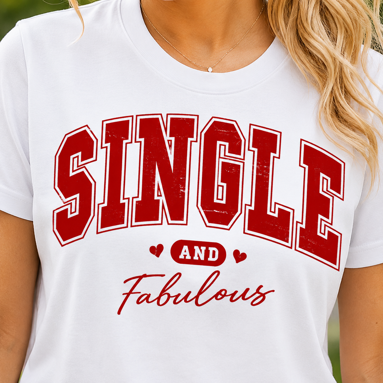 White t-shirt with red text 'SINGLE AND Fabulous' worn by a person.
