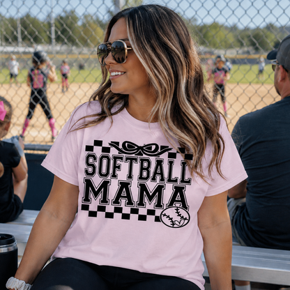 Woman wearing a 'Softball Mama' light pink colored graphic t-shirt.