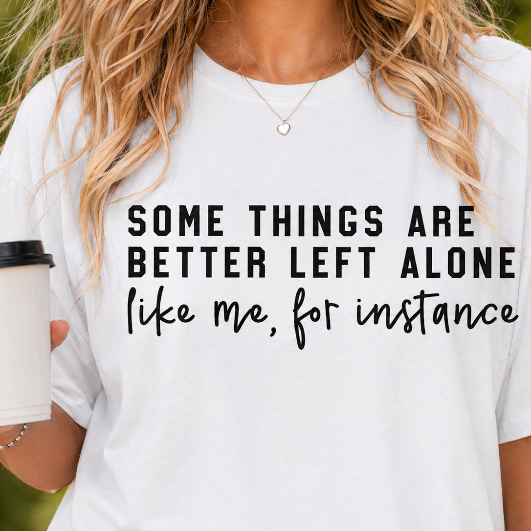 Person wearing a white t-shirt with a humorous quote, holding a coffee cup.