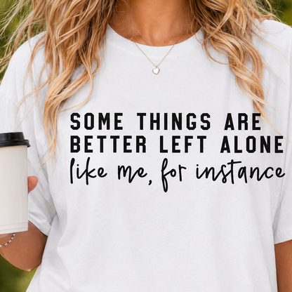 Person wearing a white t-shirt with a humorous quote, holding a coffee cup.