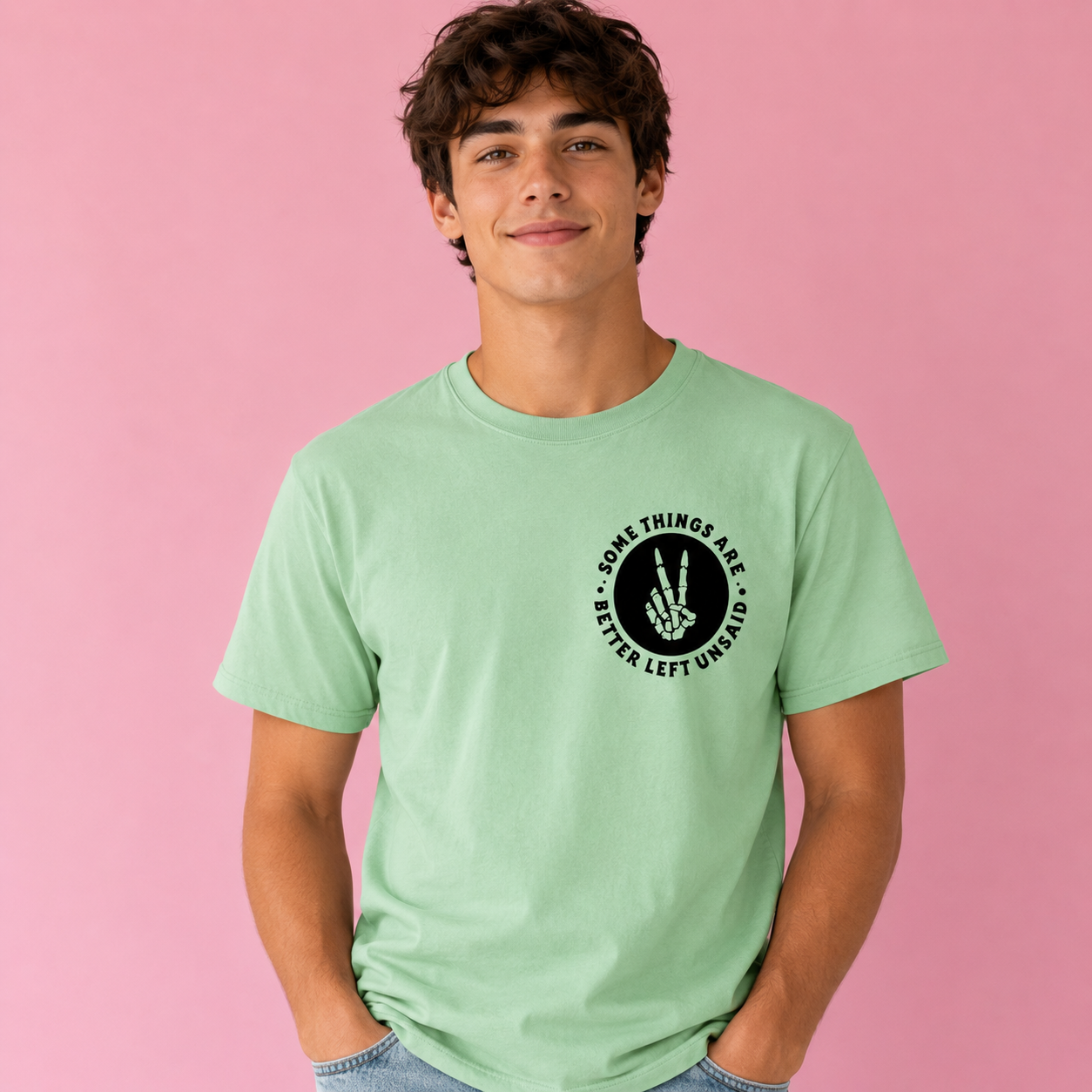 Person wearing a light green t-shirt with a black graphic and text on a pink background