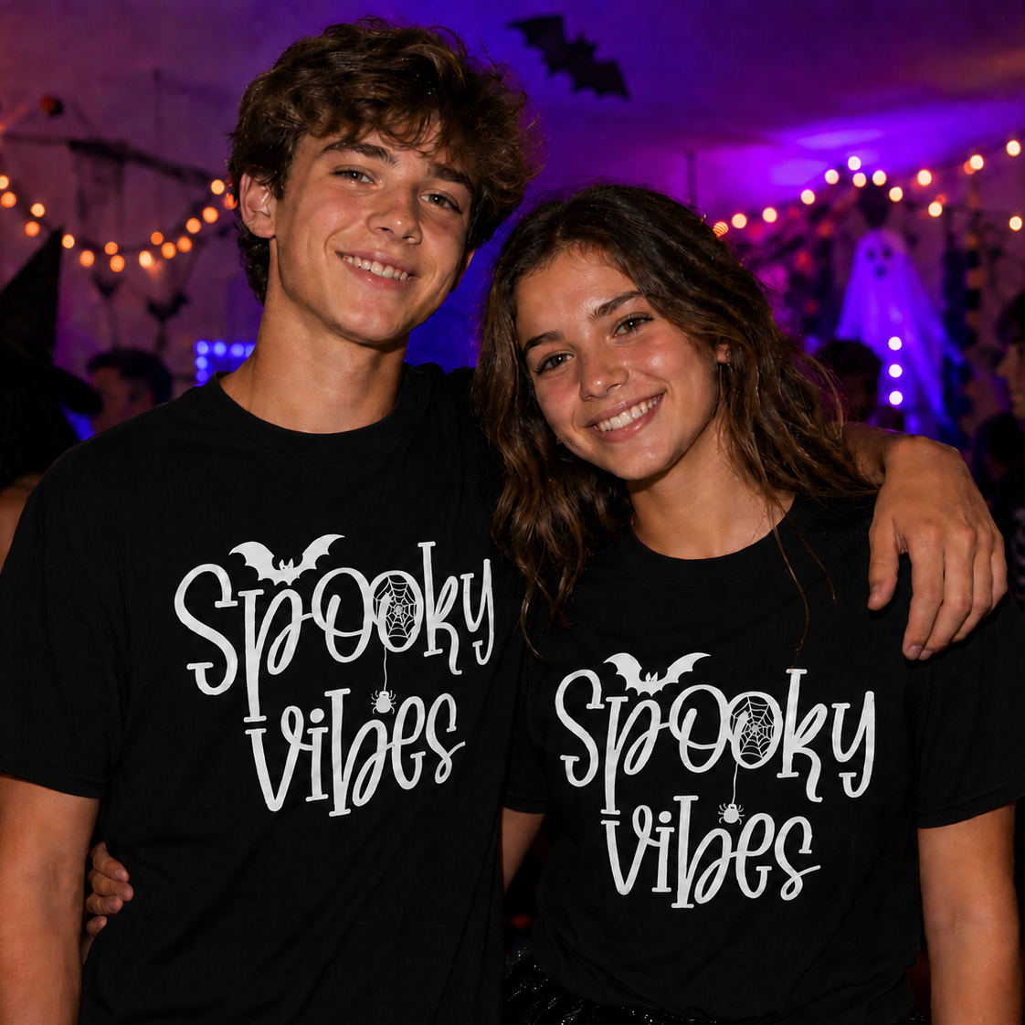 Two people wearing 'Spooky Vibes' black t-shirts in a Halloween-themed setting.