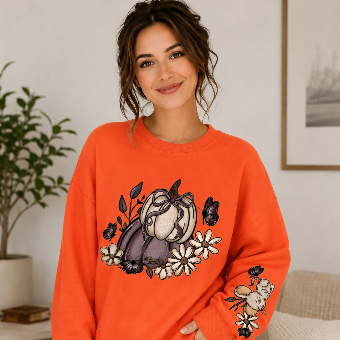 Woman wearing an orange sweatshirt with a graphic design in a living room setting