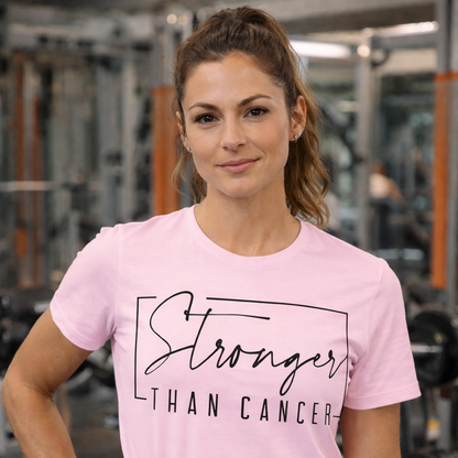 Woman wearing a pink 'Stronger Than Cancer' t-shirt in a gym setting
