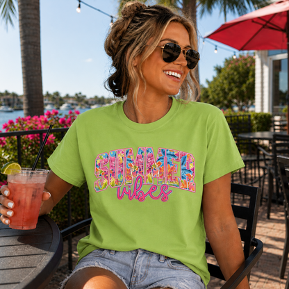 Woman wearing a lime colored 'Summer Vibes' t-shirt holding a drink outdoors.