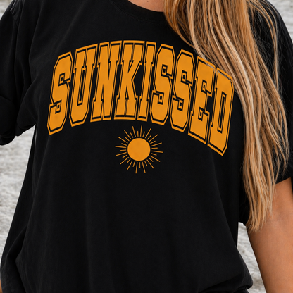 Black t-shirt with 'SUNKISSED' in yellow text and a sun graphic.