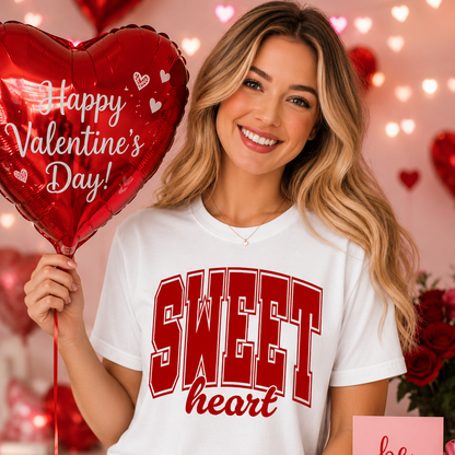 Woman wearing a 'Sweetheart' white shirt holding a Valentine's Day balloon with hearts and flowers in the background.
