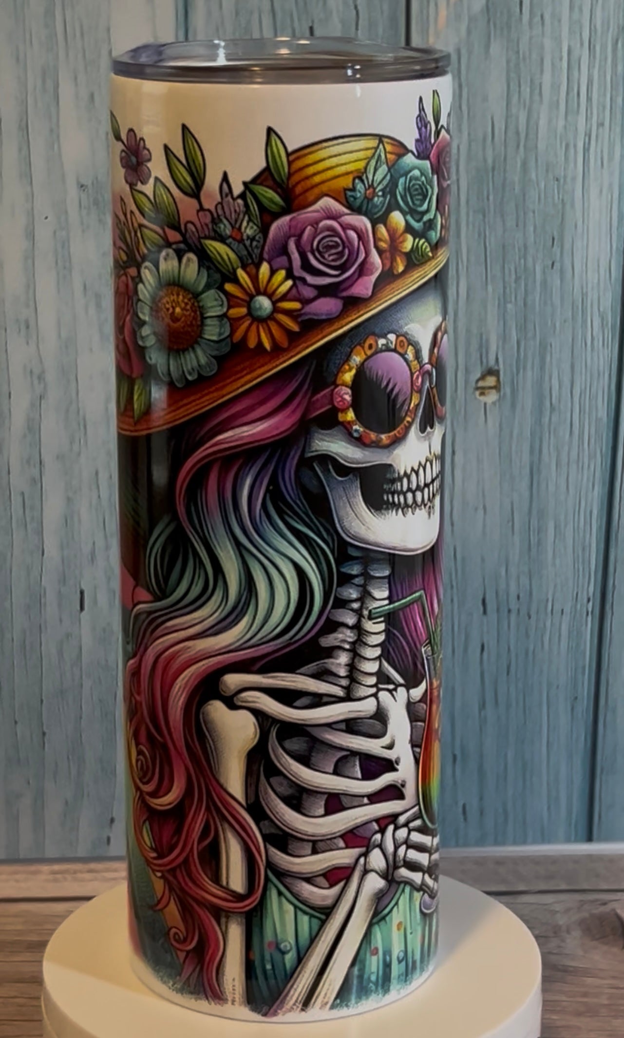 20oz tumbler featuring a tanned skeleton design, double-wall vacuum insulated, with clear sliding lid and straw, ideal for hot or cold drinks.