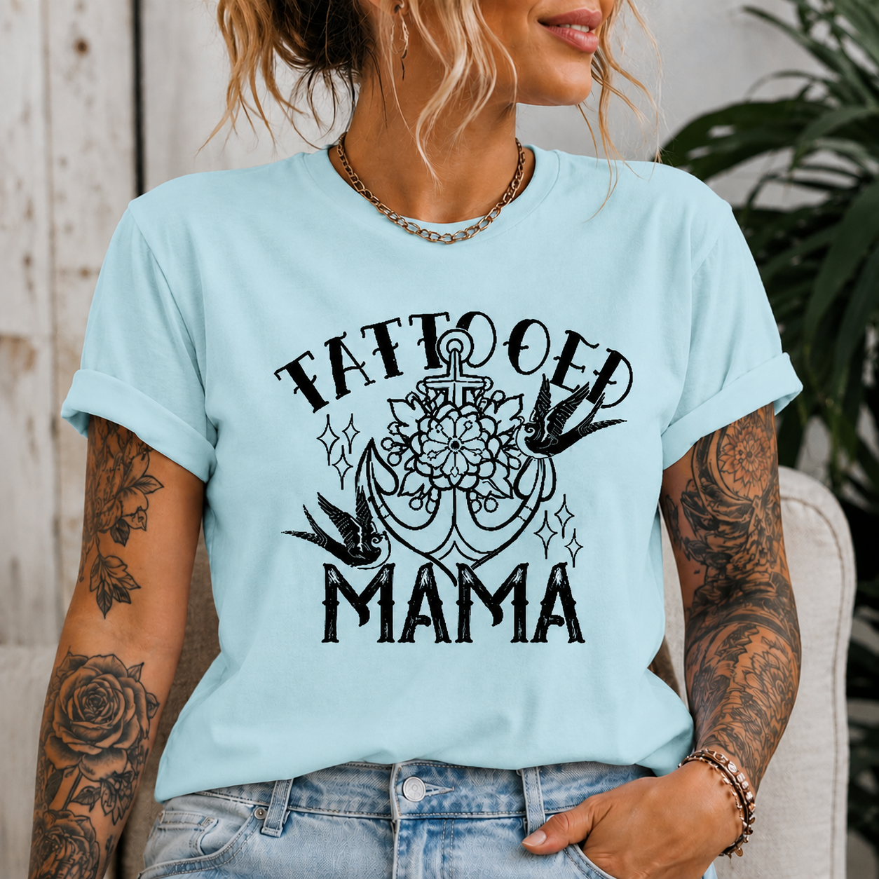 Woman wearing a chambray colored t-shirt with Tattooed Mama Graphic design