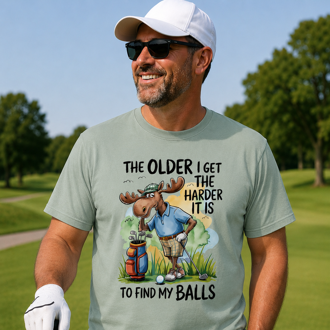 Man on a golf course wearing a t-shirt with a humorous graphic and text.