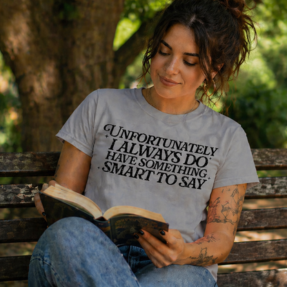 Woman reading a book on a bench in a park wearing a sport gray t-shirt with text.